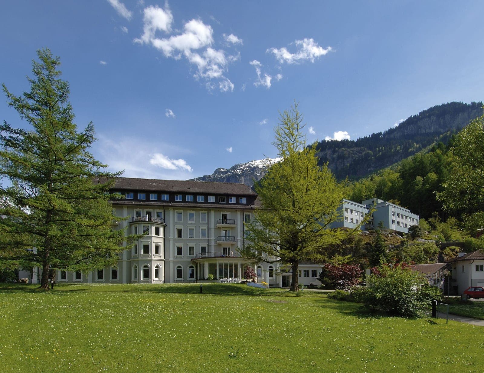 The Des Alpes building of Privatklinik Meiringen with its park